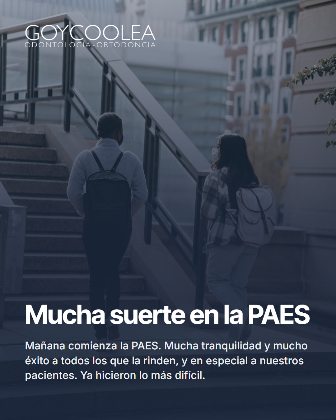 Saludo por la PAES con dos estudiantes con mochila subiendo una escalera
